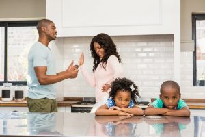 Image of parents arguing while children look sad with their head's down, showing the need for family law.